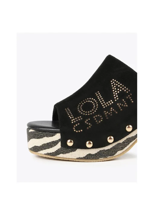 Zueco suela zebra y logo dorado.